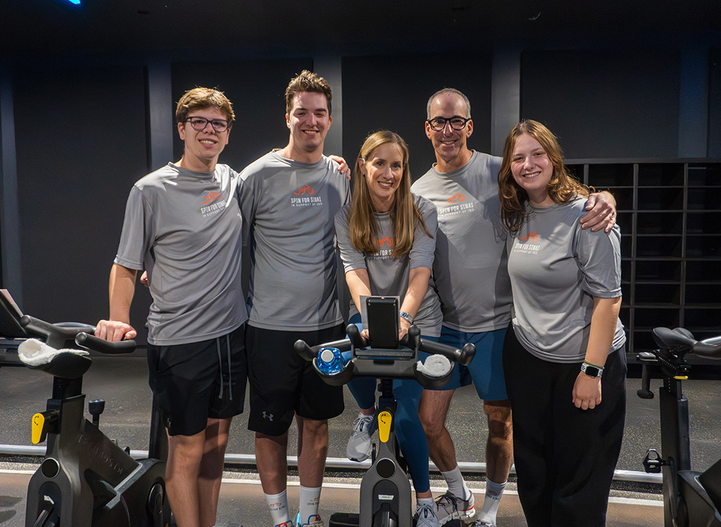 Family posing in front of stationary bikes